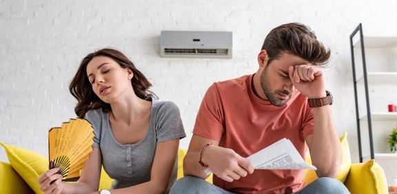 Paar sitzt verschwitzt auf Couch