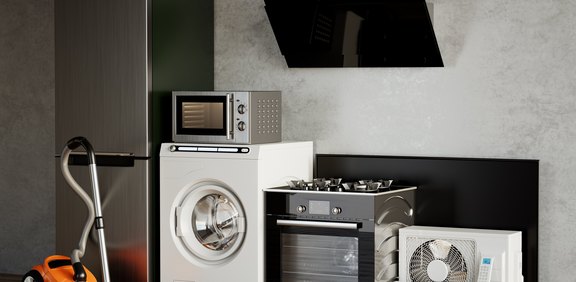 Verschiedene Haushaltsgeräte wie Kühlschrank, Waschmaschine und Herd nebeneinander.