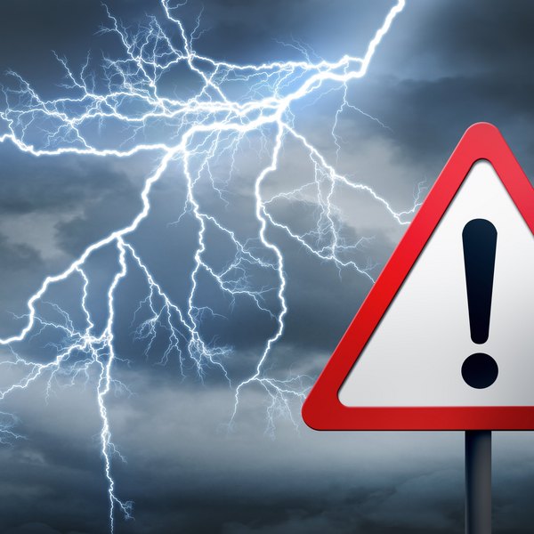 Gewitterhimmel mit Blitzen und Warnschild.